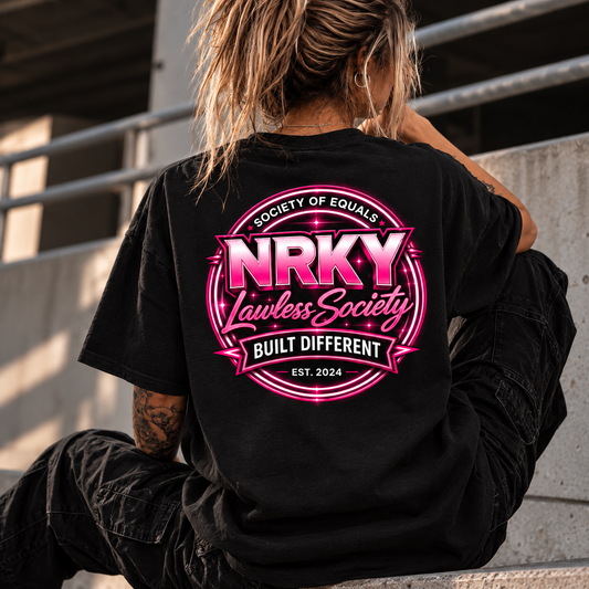 Women's Sinister Pink tee with NRKY Lawless Society hot pink back print, seated lifestyle photo